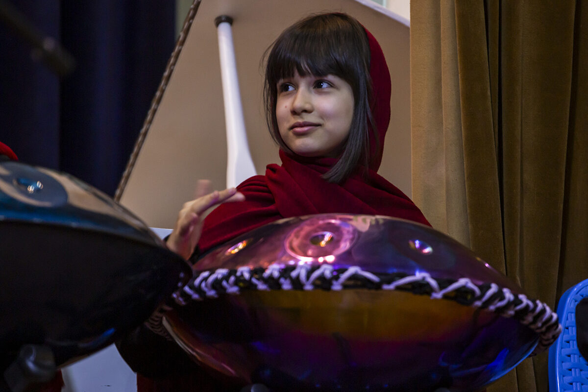 a girl playing hangdrum on stage
