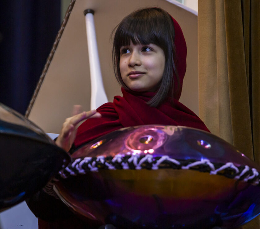 a girl playing hangdrum on stage