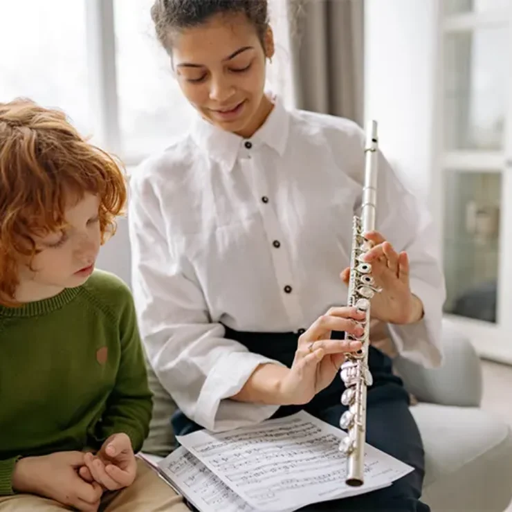 a women teaching flute to a kid