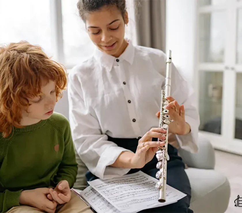 a women teaching flute to a kid