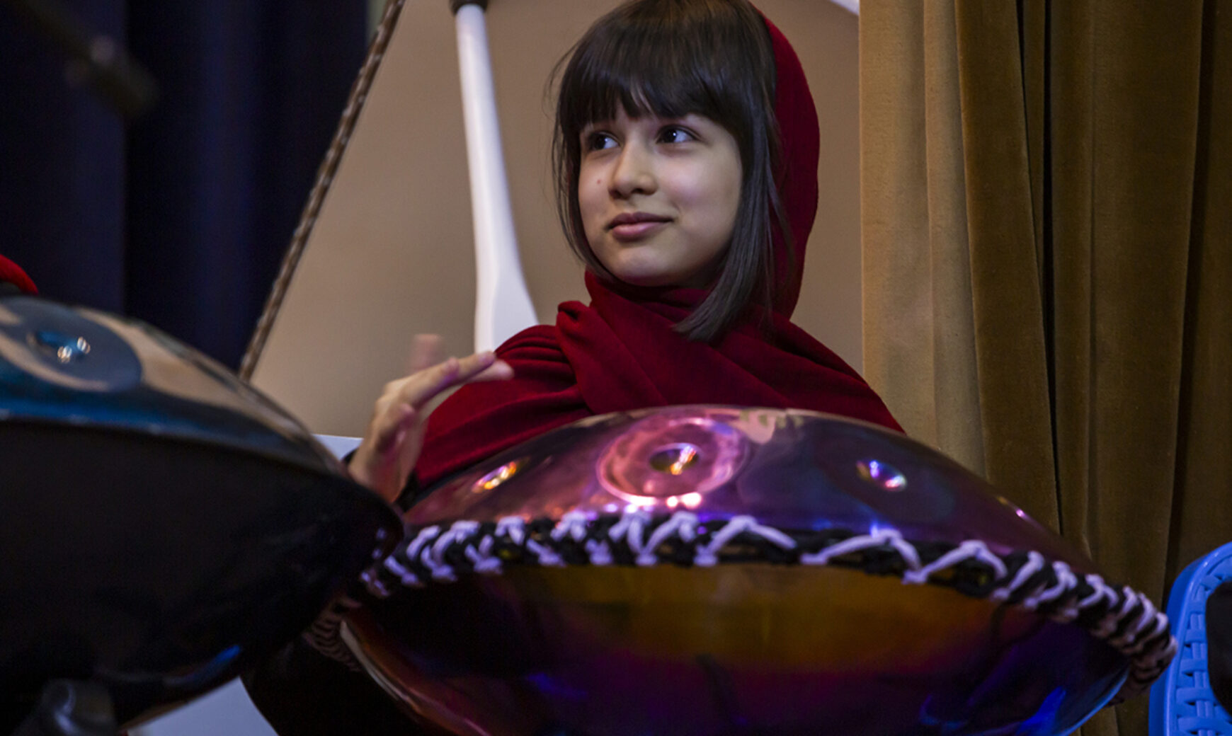 a girl playing hangdrum on stage